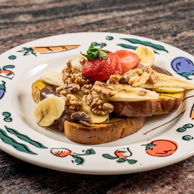 French toast, with walnuts, bananas, and strawberries.
