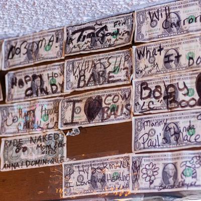 Interior, a wall decorated with signed dollar bills.