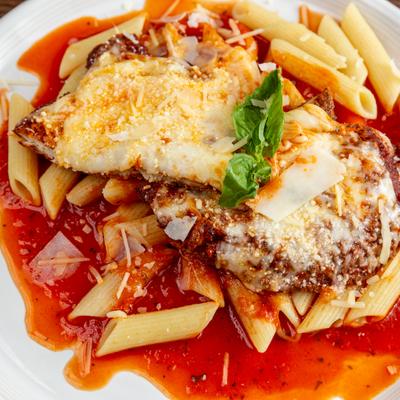 Chicken Parmesan with penne pasta, mozzarella cheese, and tomato sauce.
