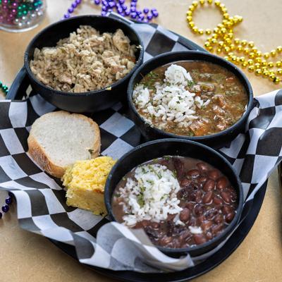 Sampler platter featuring gumbo, red beans and rice, and jambalaya.