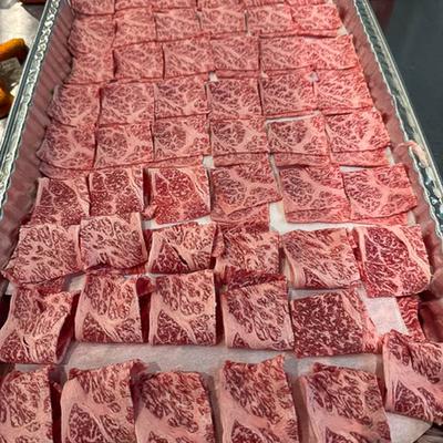 Thinly sliced marbled beef arranged neatly in rows on a tray.