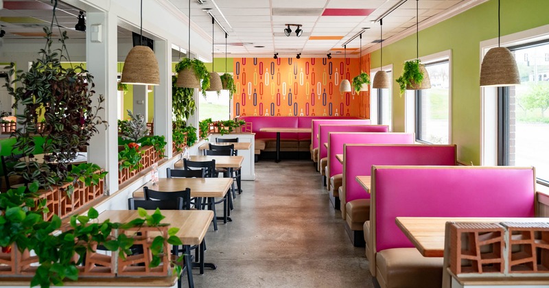 Interior, seating booths padded in violet leather, tables for two, colorful walls