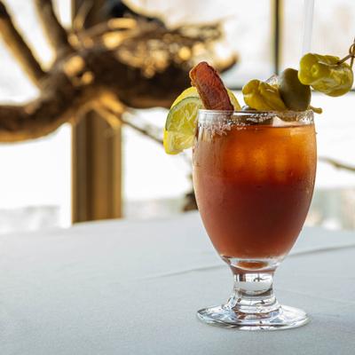 Bloody Mary garnished with bacon, lemon, olives, and pepperoncini.