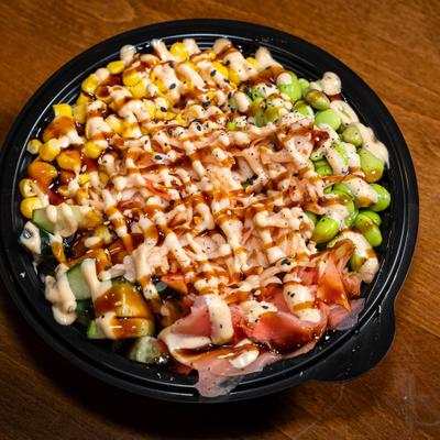 Crab poke bowl topped with edamame, sweet corn, eel sauce, and spicy mayo.