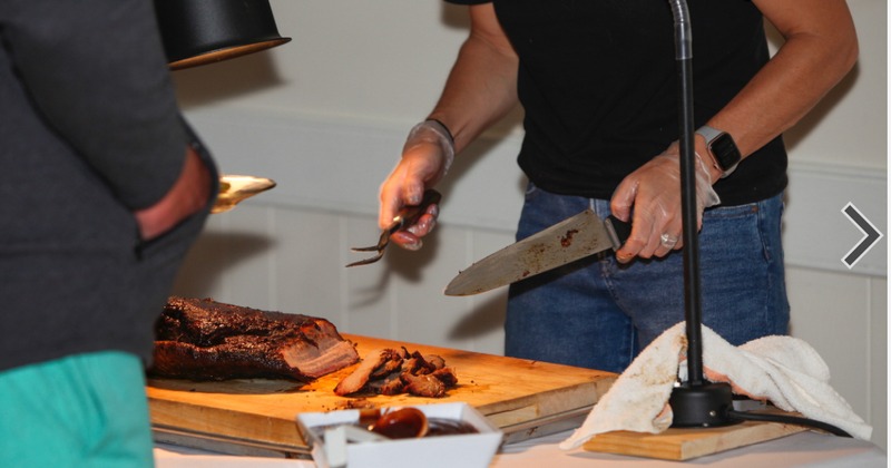 A server cutting brisket for guests