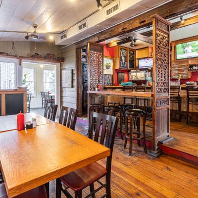 Wooden interior with a distinct bar area featuring ornate wooden dividers.