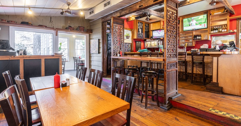 Wooden interior with a distinct bar area featuring ornate wooden dividers