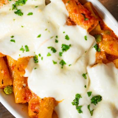 Baked Rigatoni pasta, with tomato cream sauce, peas, mozzarella, and parmesan.