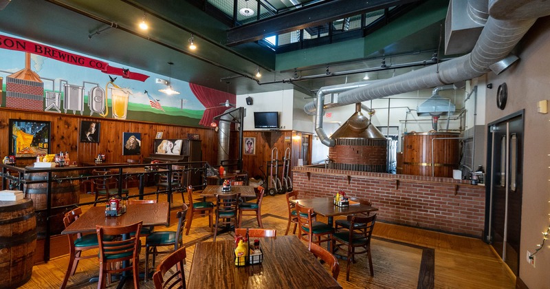 Interior, wooden tables and chairs with brewing in the back