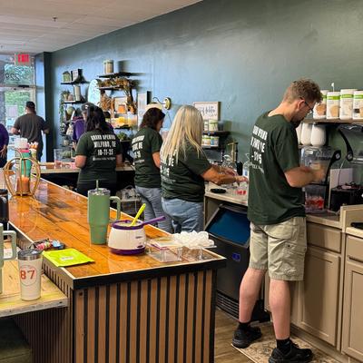 Staff members working on their stations behind the bar.