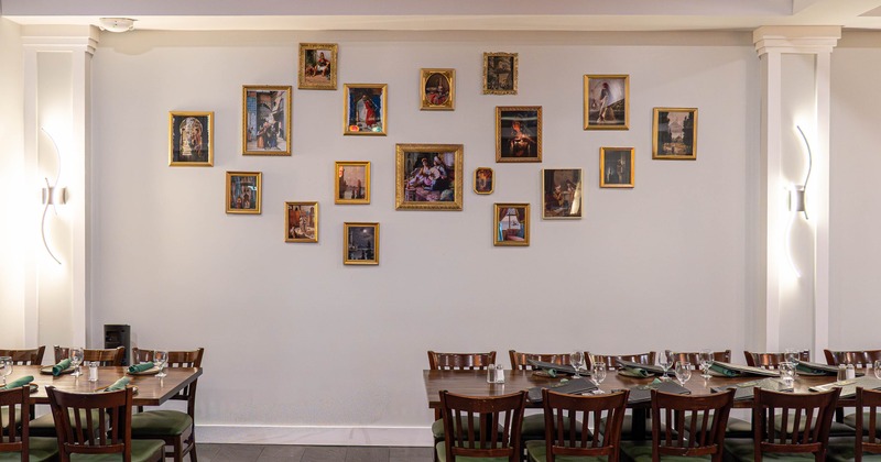 Interior, tables and chairs ready for guests with pictures on the wall
