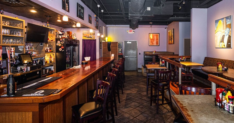 Sitting tables with bar stools on the right, and a bar on the left