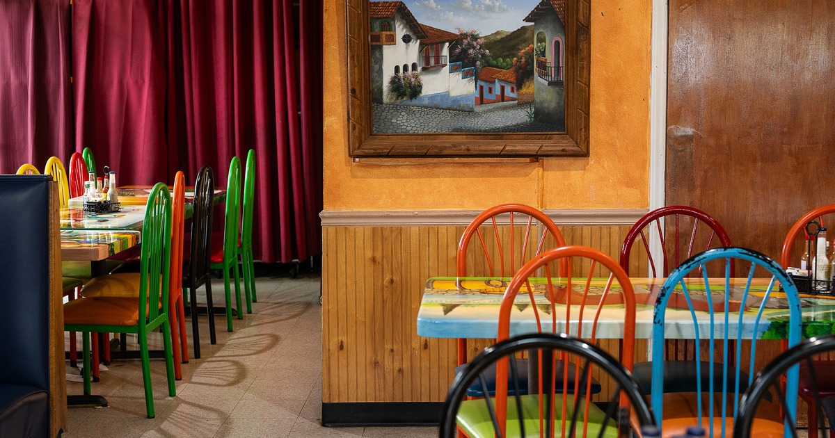 Vivid and cozy Mexican-style interior dining area with wooden tables and colorful chairs