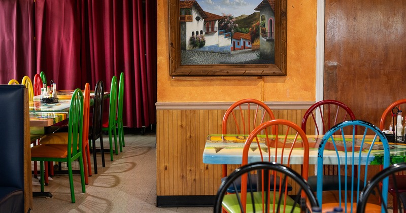 Vivid and cozy Mexican-style interior dining area with wooden tables and colorful chairs