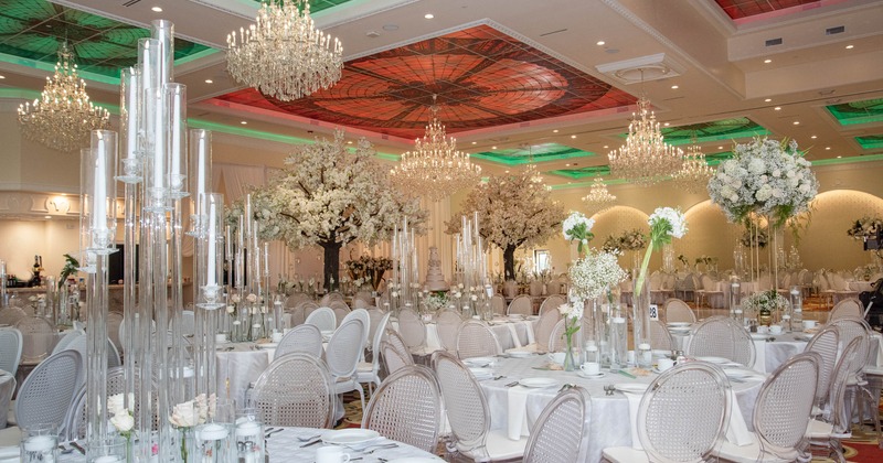 Banquet hall - crystal chandeliers, colorful glass ceiling, elegantly set tables, transparent chairs
