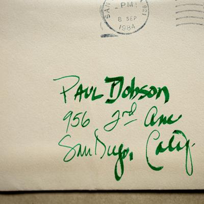An envelope with a green handwritten name and address