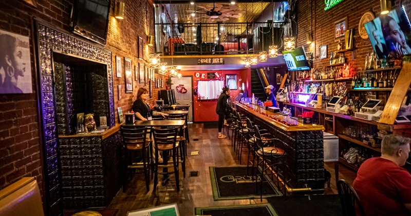 Interior, tables, chairs and bar stools lined up, bar on the right