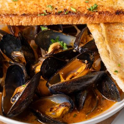 Mussels, with tomatoes, Calabrese sausage, white wine, and garlic bread.
