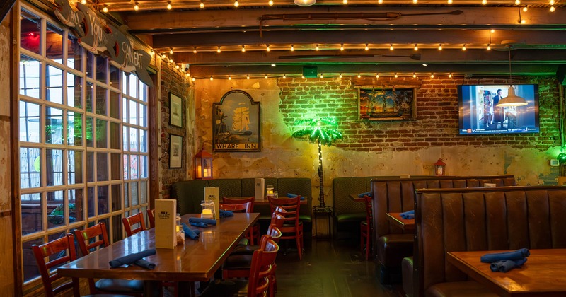 Interior, seating area, red brick wall, seating booths with tables, regular table for eight