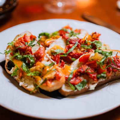 Bruschetta with roasted cherry tomatoes, ricotta cheese, and basil.