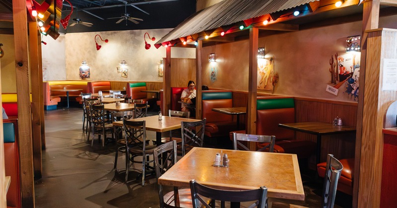 Interior, seating space with booths, tables and chairs, colorful lights