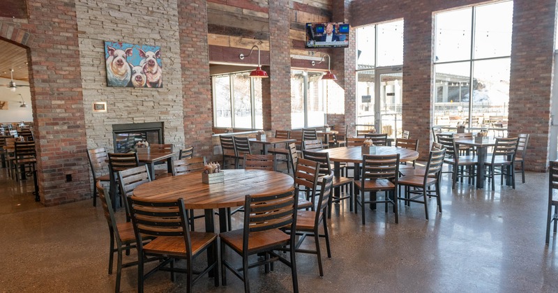 Interior, dining area, round tables with chairs, red brick and stone walls, TV on the wall