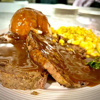 Meatloaf, with gravy, corn, and mashed potatoes.