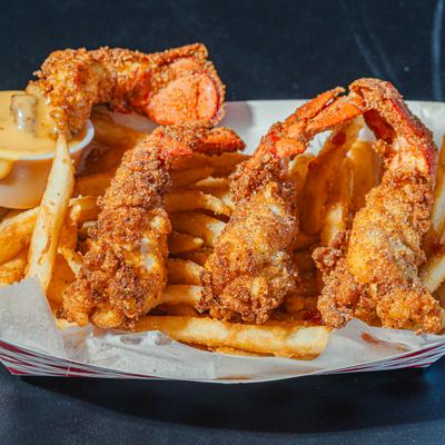 Portion of jumbo shrimp served with fries and a diping sauce.