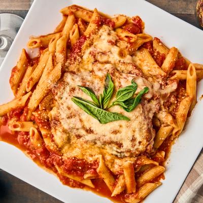 Chicken Penne in tomato sauce, topped with grated cheese and basil.
