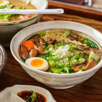 A savory bowl of Japanese shoyu ramen with egg, mushrooms, and greens.