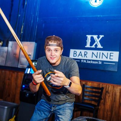 A person holding the pool que.