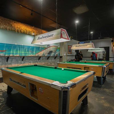 Billiard room with pool tables, sticks and balls,