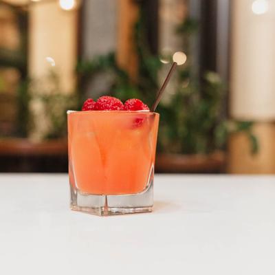 Cupid's Broken Arrow cocktail, garnished with fresh raspberries