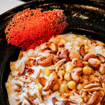 Fatteh, dish featuring layers of toasted pita, chickpeas, yogurt, and flavorful spices.