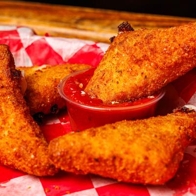 Fried mozzarella triangles served with marinara sauce, close-up.