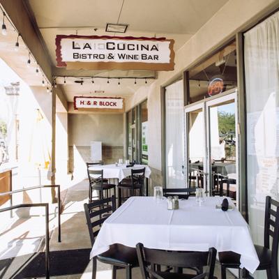 Outsine patio with table setups and restaurant's sign.