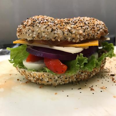 Everything bagel sandwich with veggies and cheese.