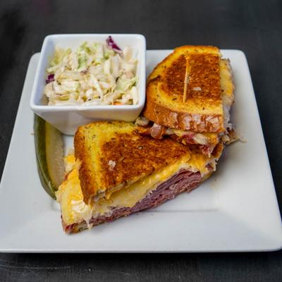 Reuben sanwich served with coleslaw on the side.