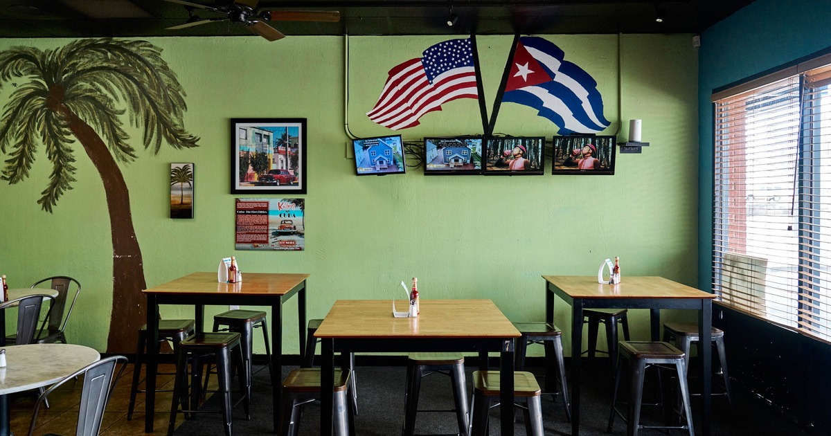 Interior, palm tree mural, framed pictures, tables and stools