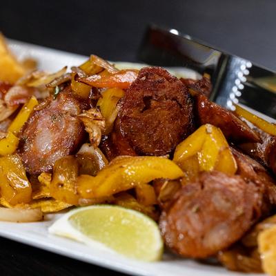 Close view of sauteed Colombian sausage with onions and peppers.