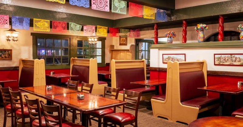 Interior of a Mexican-themed restaurant, booth seating, tables and chairs