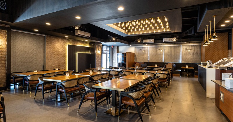 Interior seating area with tables, chairs, and decorative lighting on the ceiling