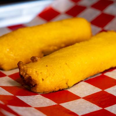 Two tamales on a red and white checkered paper.