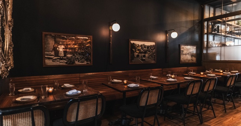 Interior, dining area, wooden banquette bench with tables for four and two, framed vintage photos