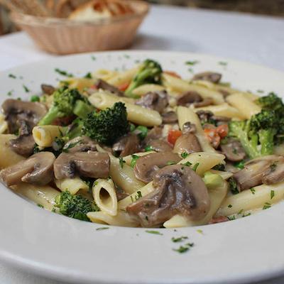 Creamy penne pasta with mushrooms, broccoli, and herbs.