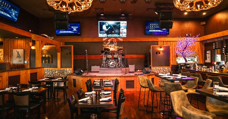 Interior, central space, seating area, stage with drums and mics, TVs on the walls