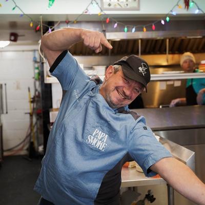 The chef making hand gestures in the kitchen.