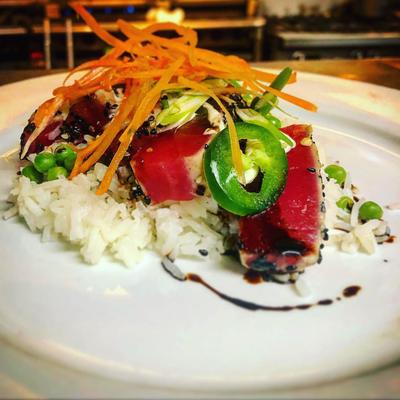 Sesame encrusted Tuna Steak, jasmine rice with green peas and wasabi tequila sauce.