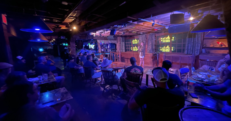 Comedy guest on stage, from crowd view