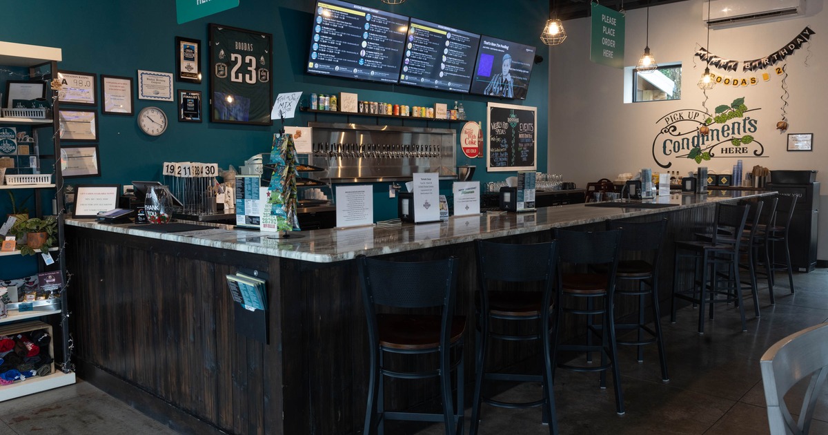 Bar interior with a long counter, menu screens, and various wall decorations